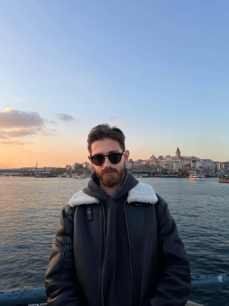 Murat Akkaş, gün batımında Haliç kıyısında; arkada Galata Kulesi